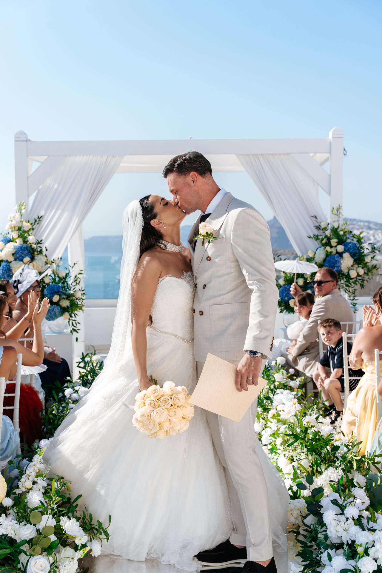 First kiss as husband and wife at a caldera-view wedding ceremony in Santorini