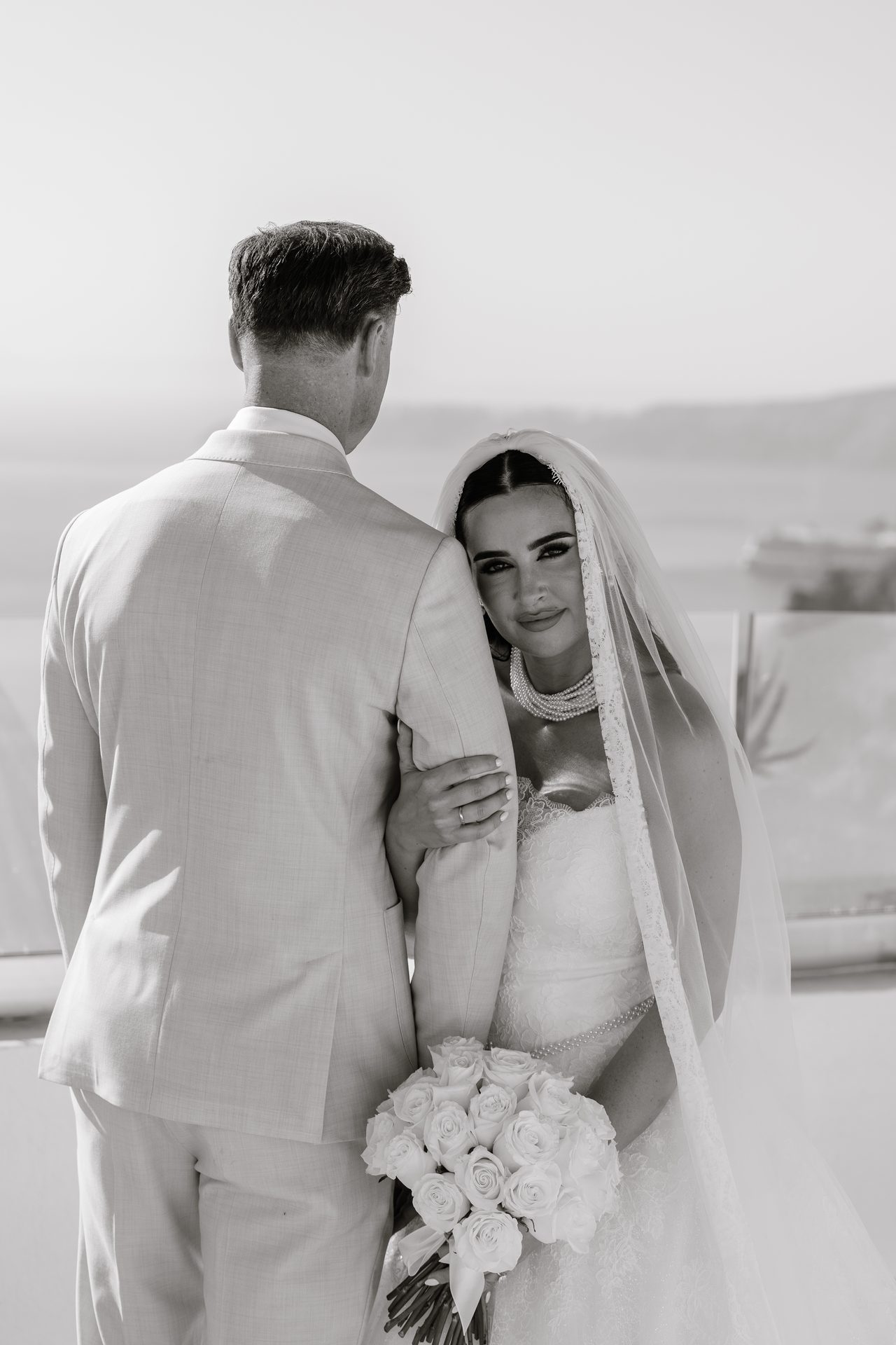 Wedding day in Santorini: bride, groom and guests at a caldera-view venue