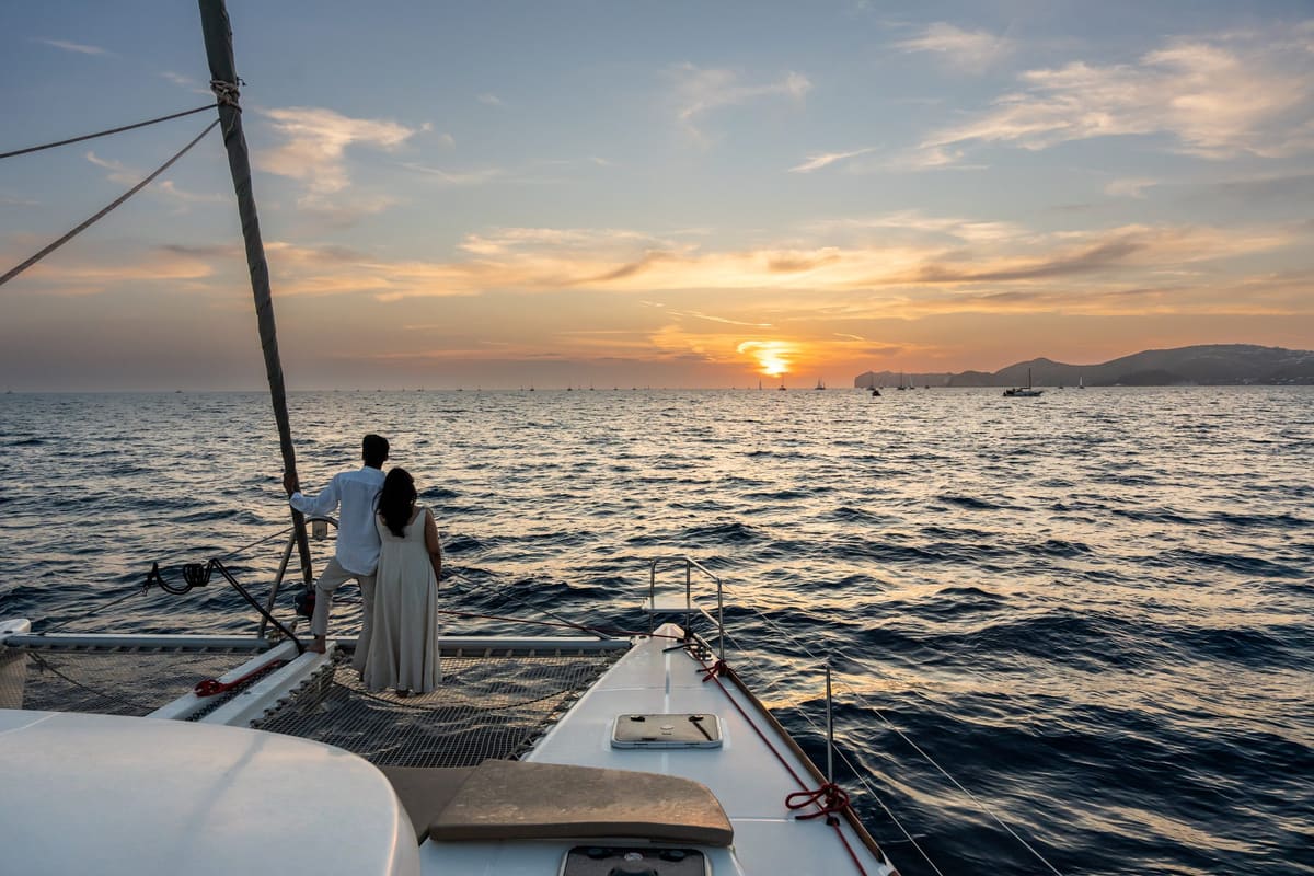 Sunset from the catamaran bow with the couple at the rail, Santorini