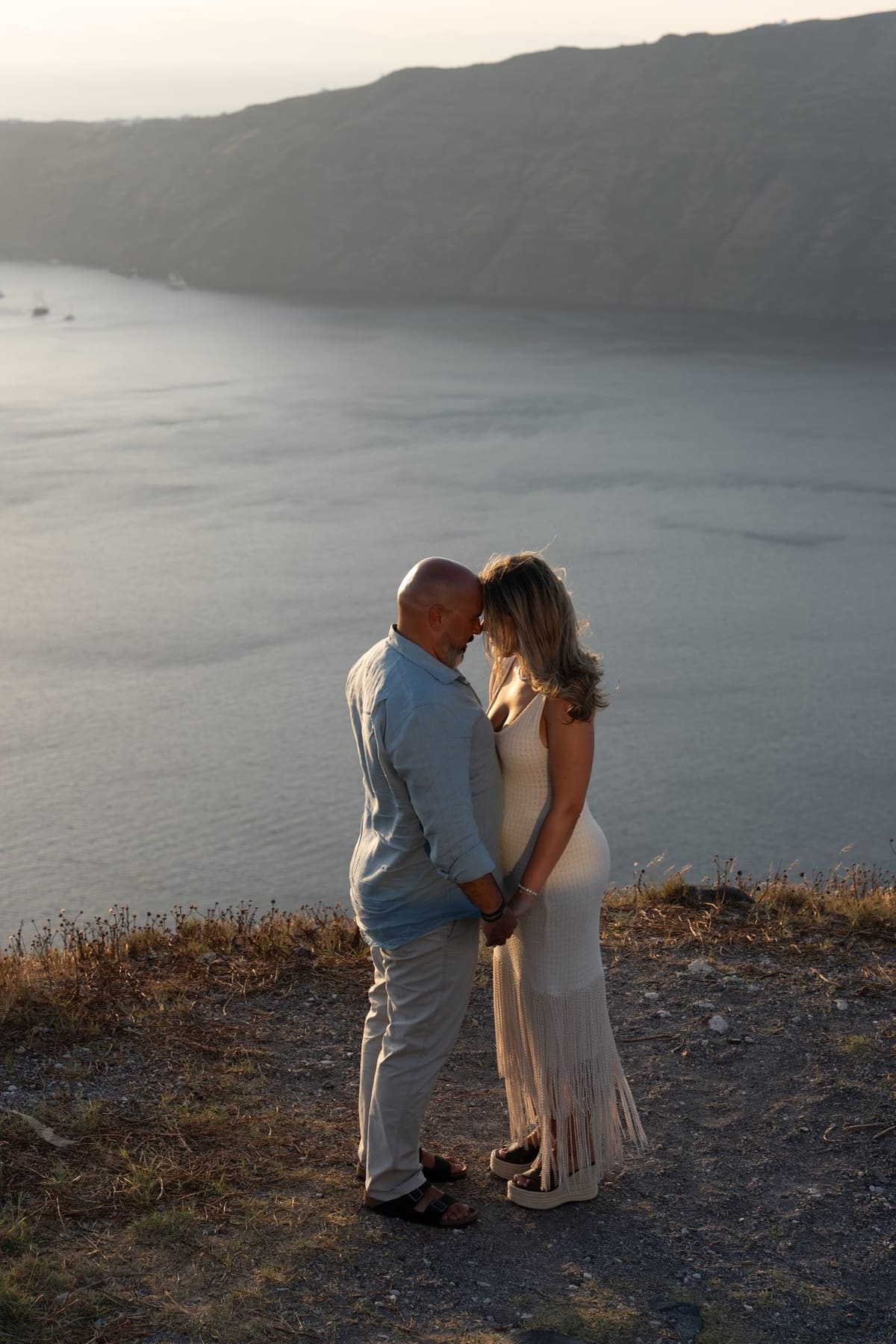Engagement portraits along the Imerovigli cliff path at dusk, Santorini