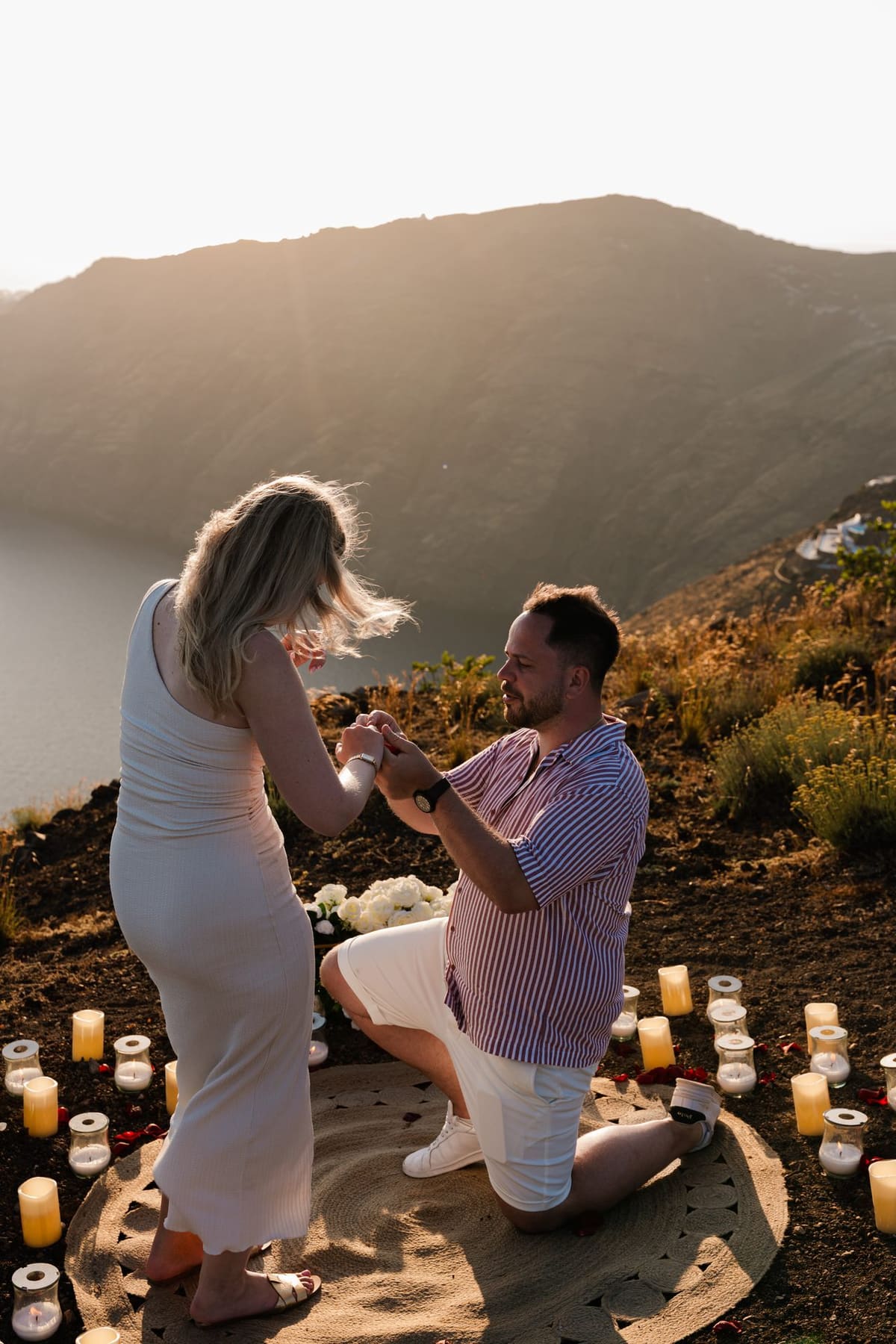 Placing the ring on her finger while kneeling among candles, Imerovigli cliff path