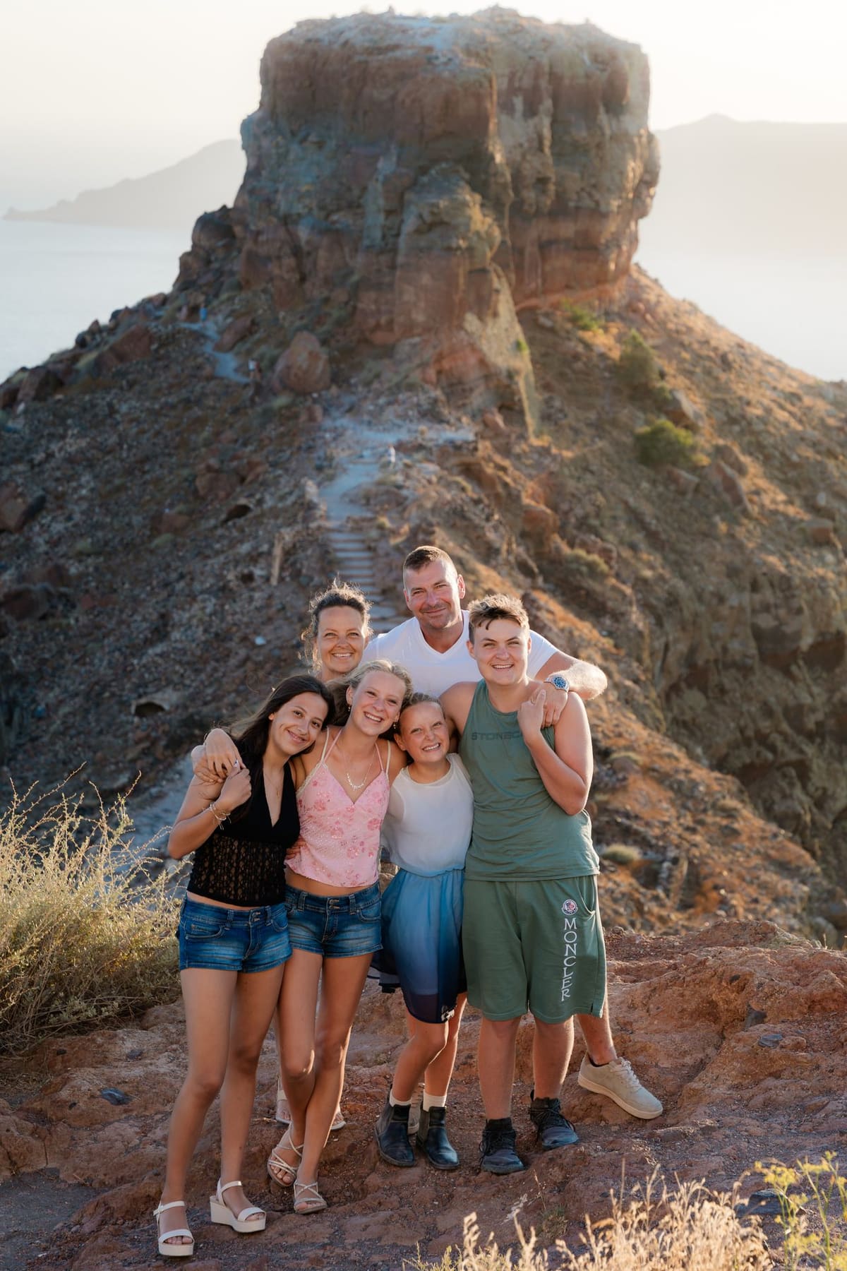 Family group portrait below Skaros Rock after the surprise proposal, Santorini