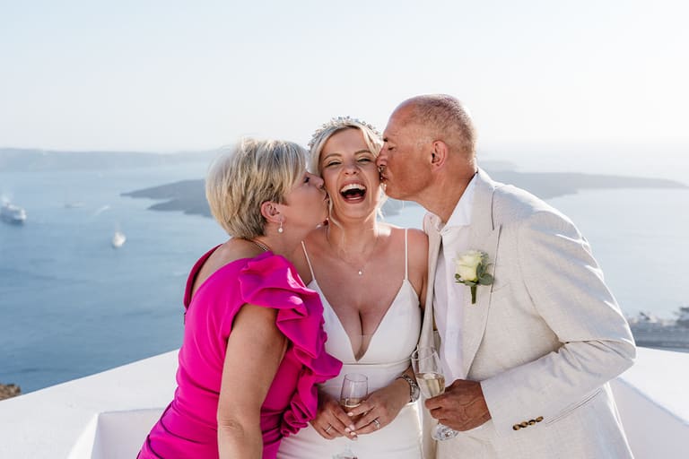 Groom hugged by family members right after the ceremony at a caldera venue in Imerovigli